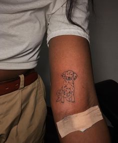 a person with a dog tattoo on their arm and the other arm is bandaged