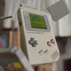 an old nintendo gameboy is being held up