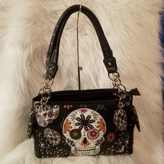 Colorful Concealable Shoulder Bag Imagery From The Mexican "Day Of The Dead" Celebration Is Printed And Has Embroidered Accents Along With A Floral Motif On The Front Of This Fashionable Shoulder Bag. The Floral Print Continues To The Back. Decorative,Studded, Trim Completes The Look. Also Featured Is A Special Zippered Pocket On The Back To Keep Your Concealable Handgun Secure And Undetectable. Has Dual Leather Chain Carrying Straps With 11 Inch Drop Length Zippered Top Opening Rectangular Shoulder Bag With Skull Print For Daily Use, Rectangular Skull Print Shoulder Bag For Daily Use, Black Skull-shaped Bag With Skull Print, Casual Black Bags With Skull Print, Daily Use Skull Print Shoulder Bag, Black Bags With Skull Print For Everyday Use, Skull Print Shoulder Bag, Skull Print Tote Bag For Daily Use, Skull Print Shoulder Bag For Everyday Use