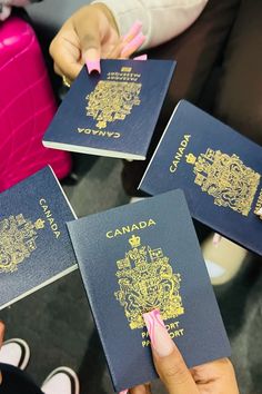 three people are holding up their canadian passports