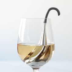 a wine glass with white wine in it and an umbrella sticking out of the side