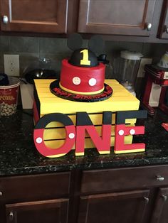 a mickey mouse cake with the number one on it sitting on top of a kitchen counter