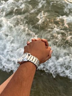 two people holding hands near the ocean waves