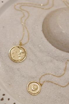 A gold rotating necklace which features the face of the sun on one side and the face of the moon on the other. Comes in 2 sizes. Small charm is 1” wide and hangs from a 16” chain Big charm is 1.5” wide and hangs from a 21” chain Vintage Sun And Moon Design Round Pendant Jewelry, Vintage Sun And Moon Round Pendant Jewelry, Moon Phase Medallion Necklace In Amulet Style, Moon Phase Medallion Necklaces Styled As Amulets, Gold Medallion Necklace With Sun Design, Spiritual Sun And Moon Medallion Necklace, Amulet Style Necklace With Sun And Moon Design, Gold Sun Design Round Pendant Necklace, Gold Necklace With Sun Design Round Pendant