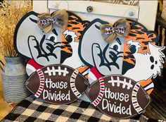 two football shaped signs with the words house divided written on them and decorated with tiger heads