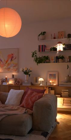 a living room filled with lots of furniture next to a lamp and bookshelf