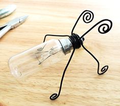 a light bulb sitting on top of a wooden table next to scissors and a pen