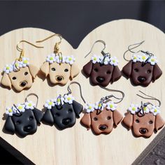 the dog earrings are decorated with daisies on them, and have been placed in a heart shape