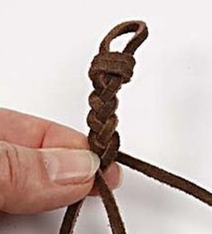 a hand holding a piece of brown rope