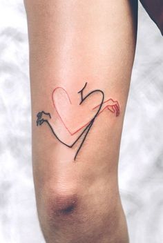 a woman's arm with a heart and arrow tattoo on the left side of her arm