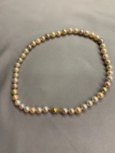 Multi Color South Sea and Freshwater Pearl Necklace. This stunning one of a kind necklace features 47 Multi Color South Sea and Freshwater Pearls AAA High Luster Round 8.25-10.4 mm Genuine and Natural, white, cream, gold, pink, apricot, lavender all hand knotted with white silk thread and finished with a 14K yellow gold mixed texture round bead clasp 8mm. The necklace measures 18 1/2 inches in length. The necklace pictured is the one you will receive. Color may vary due to light. Images are take Multicolor High Luster Necklaces As Gift, Multicolor High Luster Necklace For Gift, Elegant Multicolor Pearl Necklace For Formal Occasions, Elegant Multicolor High Luster Necklaces, Elegant Multicolor Single Strand Necklace, Elegant Multicolor Pearl Necklace Gift, Elegant Multicolor Single Strand Pearl Necklace, Multicolor Single Strand Round Pearl Necklace, Pink Akoya Pearl Round Necklace