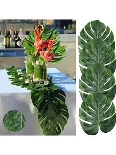 a table topped with a vase filled with flowers next to a large green leafy plant