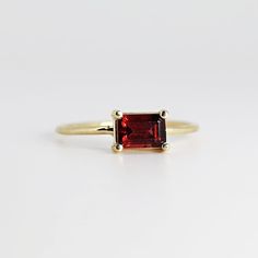 This beautiful Emerald Cut Garnet Gold Ring was handmade in Melt'm Jewelry Design Studio in California using 14k solid yellow gold band and 6x4mm emerald cut natural garnet stone. Garnet is featuring in 14k gold prong setting. DETAILS ABOUT THE RING, MATERIAL AND STONES Ring Band: 14K solid gold Ring Band size: 1 mm thick Gemstone: Garnet Garnet size: 6mm x 4mm emerald cut It is a great birthday gift for your special ones whose birthday are in January, since Garnet is January birthstone. This so Garnet Gold Ring, Gold Ring Band, Jewelry Design Studio, January Birthstone Rings, Garnet Engagement Ring, Red Garnet Ring, Garnet And Gold, Solid Gold Ring, January Birthstone