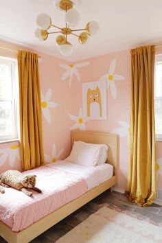 a child's bedroom with pink walls and yellow curtains