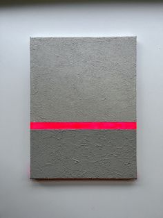 an abstract painting with grey and red lines on the bottom, against a white wall