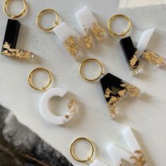 several pairs of gold and white rings sitting on top of a marble slabd surface