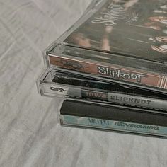 three cd's are stacked on top of each other, one is black and the other is silver