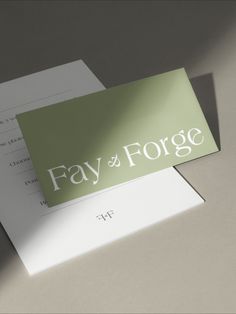 two folded business cards sitting on top of each other with the word, fay & forget