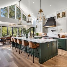 a large kitchen with wooden floors and green cabinets