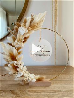 a white and brown feather wreath on a wooden table with a mirror in the background