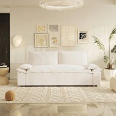 a living room with white furniture and art on the wall