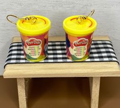 two plastic yogurt cups sitting on top of a table next to each other