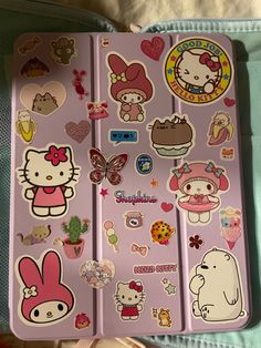 hello kitty stickers on the side of a pink suitcase