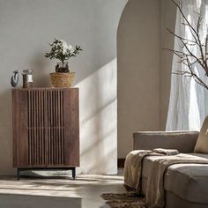 a living room with a couch, table and vases on top of the tables