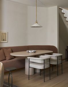 a living room filled with furniture next to a stair case and wooden floored stairs