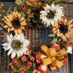 a wreath with sunflowers and other flowers on top of a metal door frame