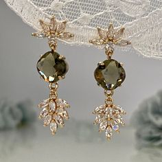 Step into the enchanting world of vintage glamour with our Brown Crystal Wedding Chandelier Earrings, an exquisite choice for brides, bridesmaids, and anyone looking to shine on a special occasion. The design echoes the opulence of the Art Deco era, featuring a half-flower post dazzling with marquise-cut clear cubic zirconia, leading to a smoky quartz-inspired crystal that captures and transforms light from every angle. An elegant leaf-shaped drop, encrusted with brilliant cubic zirconia, comple Vintage Wedding Earrings Brides, Vintage Wedding Earrings, Wedding Drop Earrings, Jewelry For Bridesmaids, Smoky Quartz Jewelry, Smoky Quartz Earrings, Deco Chandelier, Wedding Chandelier, Glamour Vintage