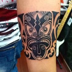 a tattoo on the arm of a man with an animal face in black and grey