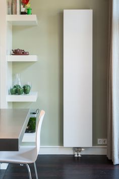 a table and chairs in a room with shelves on the wall