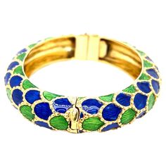 Tiffany & Co. 18 karat yellow gold bangle bracelet with royal blue and green enamel. It features a fish scale design throughout. Marked: Tiffany / 18k. Total weight: 82.9 grams. Width: 3 inches. Length: 2.75 inches. Inner circumference: 7 inches. Tiffany And Co Bracelet, Yellow Gold Bangle, Gold Armband, Gold Bangle Bracelet, Tiffany And Co, Green Enamel, Gold Enamel, Gold Bangles, Tiffany & Co.