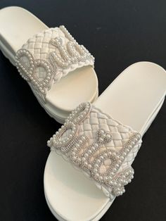 All Leather Bridal slip on slide Platform sandals. Custom made with silver and pearl "Bride " lettering along wide leather strap. These are Soooo comfy. Perfect for throwing off heels to wear at reception. Wedged to 3 inches !!   Great Gift idea for bachelorette parties, Showers, Engagement parties, Honeymoon..  Rush orders are welcome for a quick next day shipping! Exchanges and Refunds are offered. Contact Audrey for questions 24/7 . Custom ideas are always welcome if you have something else in mind.. Silver Open Toe Wedding Shoes For Bridal Shower, White Pearl Open Toe Wedding Shoes, White Pearl Wedding Shoes For Summer, Summer Pearl White Wedding Shoes, Bride Sandals, Bridal Flip Flops, Beach Wedding Shoes, Pearl Bride, Sandals Wedding