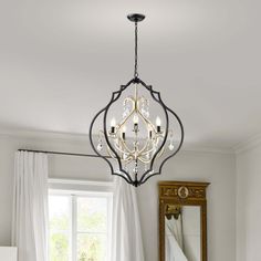 a chandelier hanging from the ceiling in a room with white walls and curtains