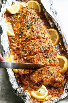 fish covered in foil with lemons and parsley