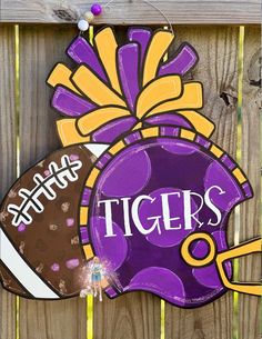 a purple and yellow sign that says tigers on it with a football in the center