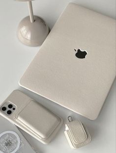 an apple laptop computer sitting on top of a table next to a phone and other accessories