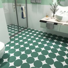 a bathroom with green and white tiles on the floor