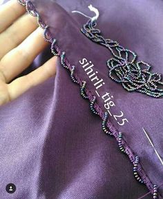 someone is stitching together beads on a purple shirt with the word smile in white