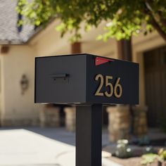 a black mailbox with the number twenty six on it in front of a house