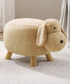 a sheep shaped stool sitting on top of a white rug