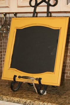 a chalk board attached to a hook on a kitchen counter