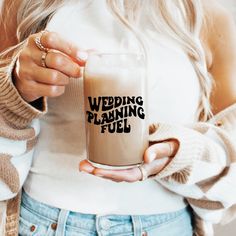 a woman holding a coffee mug with the words wedding planning fuel printed on it