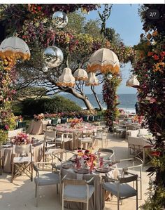 an outdoor dining area with umbrellas and tables set up for formal function at the beach