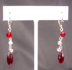 "Stunning ruby red Swarovski Elements briolette teardrops sway from petite sterling silver chains. The red crystal is accented by Swarovski Elements aurora borealis crystals. These cascade earrings have decorative sterling silver lever back ear wires and are 2 inches (51 mm) long. Sterling silver ear hooks are also available. Free USPS first class domestic shipping on all KBeadsIt jewelry. Matching necklace (last picture): https://www.etsy.com/listing/558422442 See my entire collection at https: Swarovski Heart Earrings, Cascade Earrings, Jewelry Matching, Element Necklace, Crystal Heart Earrings, Crystal Teardrop Earrings, Freshwater Pearl Jewelry, July Birthday, Buy Bead