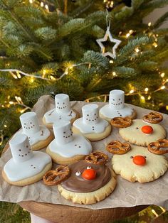 there are many decorated cookies and pretzels in front of a christmas tree with lights