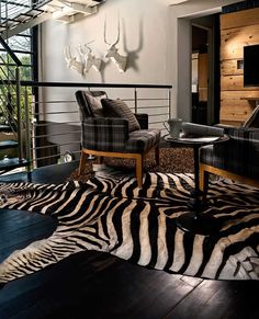 a living room with zebra print rug and chairs