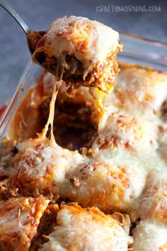 a spoon full of lasagna casserole being lifted from the casserole dish